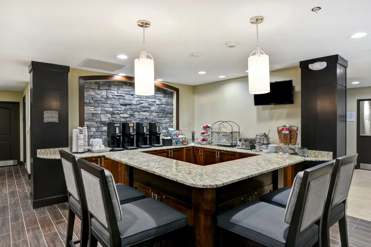 A welcoming breakfast area featuring a granite countertop, a stone feature wall, and a display with coffee machines and snacks. This communal space invites guests to gather for a morning meal or coffee before heading out for the day's adventures.